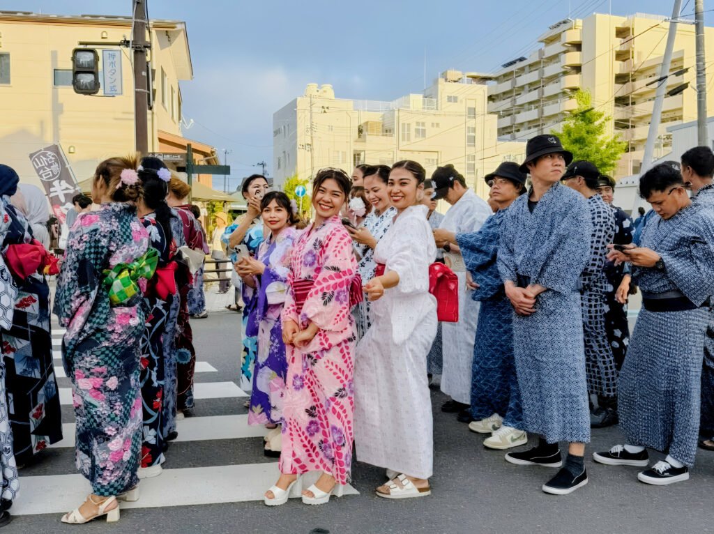 Group of people wearing colorful yukata at a Japanese summer festival.