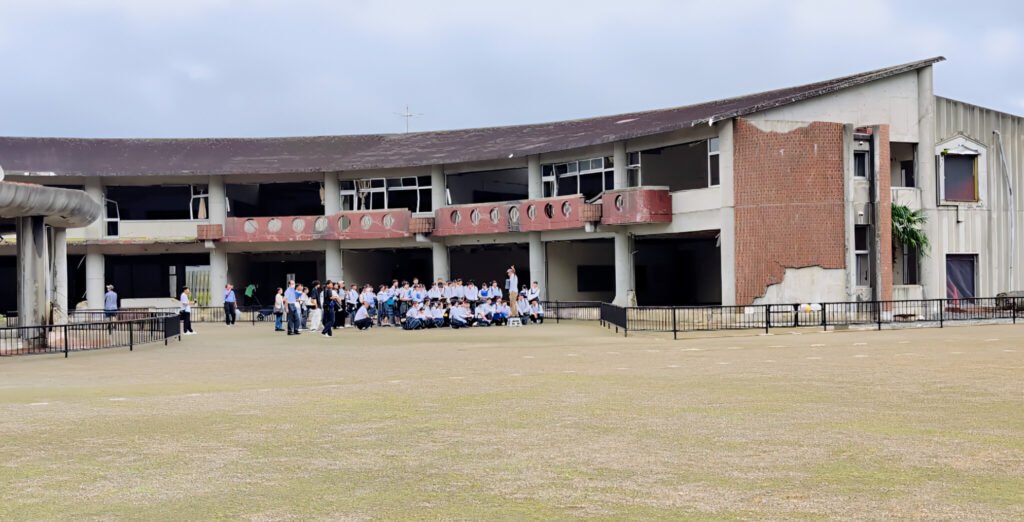Okawa School Tsunami Memorial – Stories of Hope and Resilience Okawa Elementary School ruins in Ishinomaki with visitors paying respects after the 2011 tsunami.