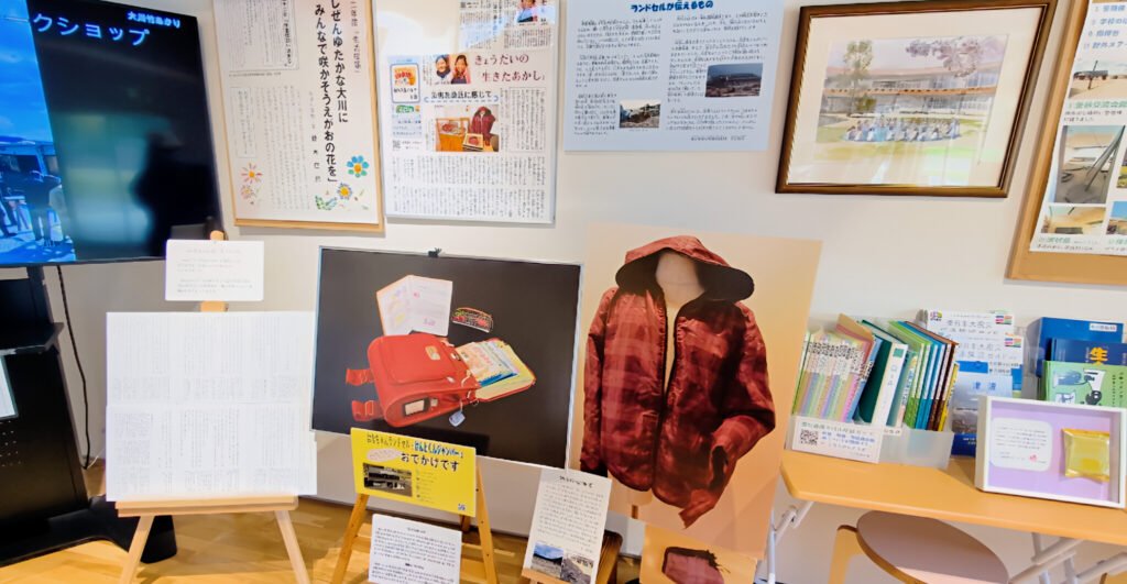 Okawa School Tsunami Memorial – Stories of Hope and Resilience Exhibit inside Okawa Tsunami Memorial Hall showing a child’s red school bag, jacket, and notebooks from Okawa Elementary School.