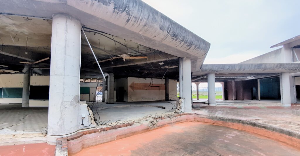 Okawa School Tsunami Memorial – Stories of Hope and Resilience Interior pillars and collapsed ceiling inside Okawa Elementary School ruins, showing damage from the tsunami.