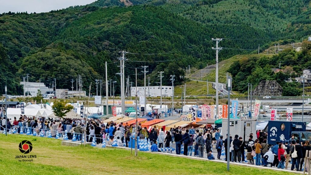 Long line of visitors waiting for grilled sanma at Onagawa Harvest Festival 2025, Miyagi Prefecture, Japan — photo by Japan Lens by GraceyG.