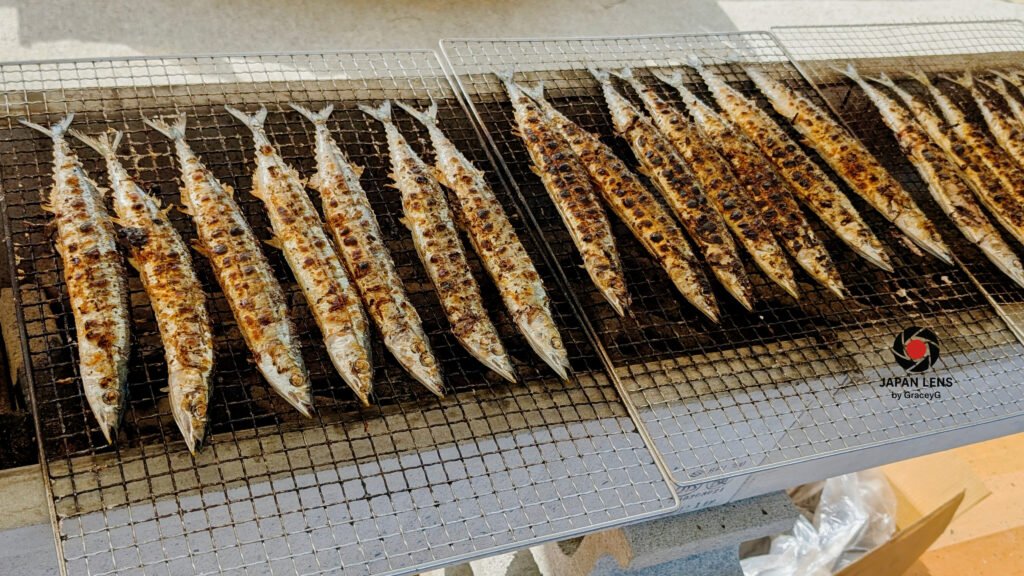 Golden-brown grilled Pacific saury on charcoal racks at Onagawa Harvest Festival 2025, Miyagi, Japan — symbolizing the flavor of autumn and community spirit. Captured by Japan Lens by GraceyG.