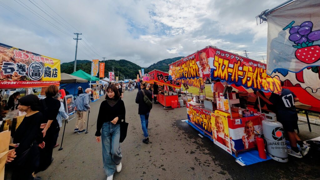 Colorful food stalls and festival-goers at Onagawa Harvest Festival 2025, Miyagi, Japan — capturing the lively spirit, local flavors, and joyful energy of Japan’s autumn celebration. Photo by Japan Lens by GraceyG.