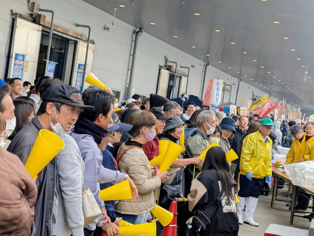 Visitors holding yellow cones while lining up during Ishinomaki Taigyō Matsuri