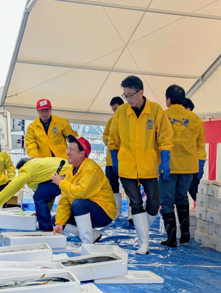 Taigyō Matsuri auction leaders in yellow jackets preparing fresh seafood during Ishinomaki Taigyō Matsuri